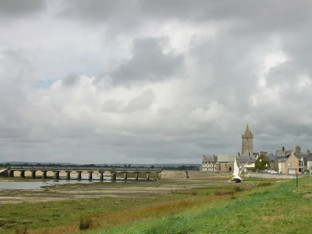 Le pont de Portbail sur le havre à marée basse, avec l’église Notre-Dame et le village